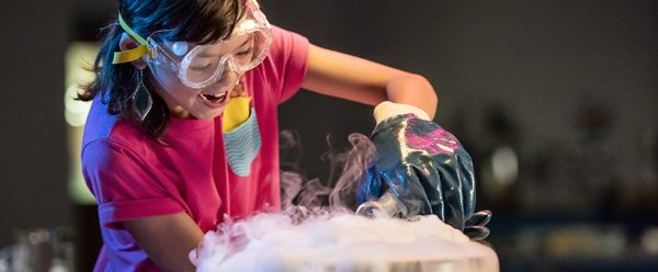 A young person performing a science experiment using dry ice.