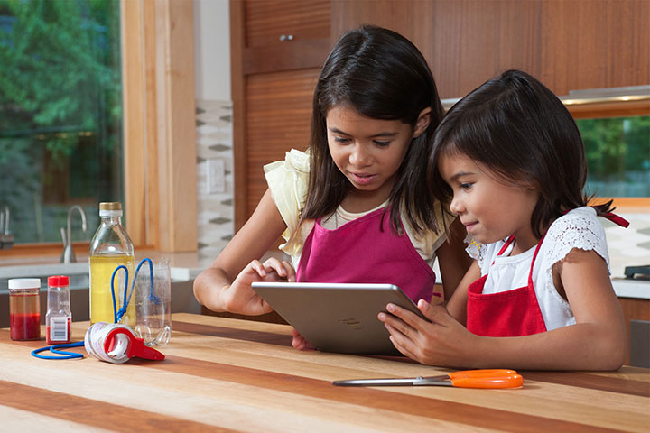 Two children using an app on their tablet.