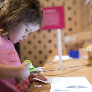 A child creating her own invention at the Make Station exhibit