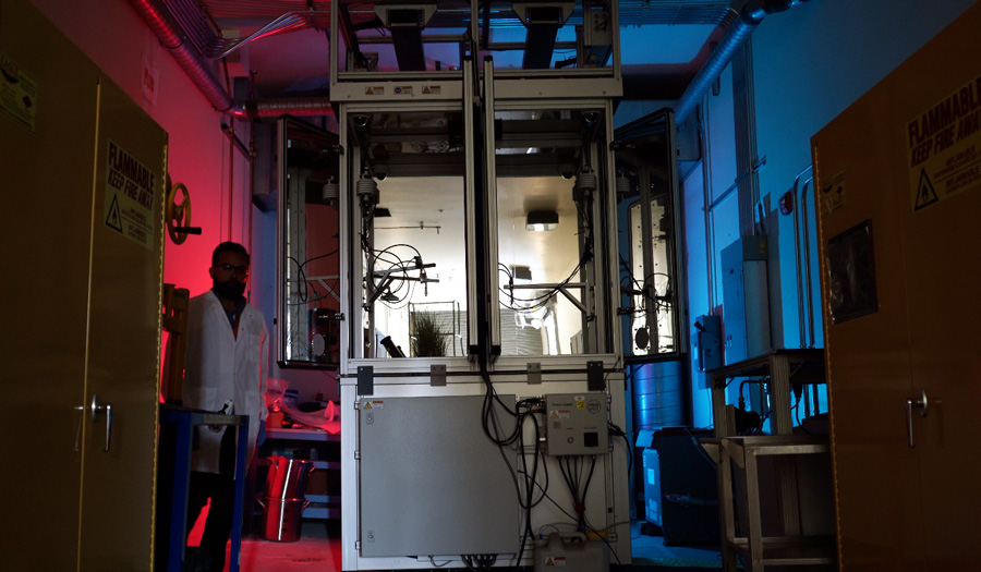 A person standing inside a science laboratory with different types of equipment